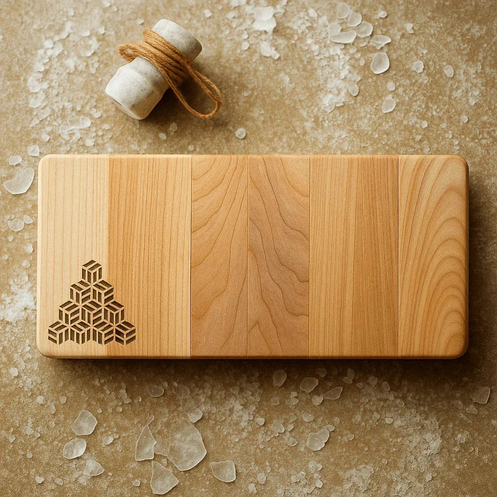 Tessera Artisan wooden serving board with geometric cube design on natural textured surface with small stone and twine