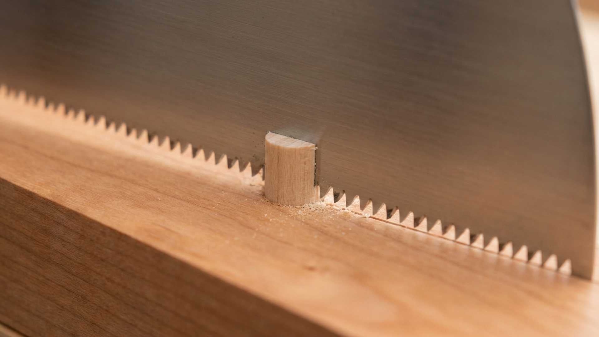 Japanese pull saw cutting technique demonstrated at The Makers Society workshop, showing controlled pull stroke and precision hand tool use