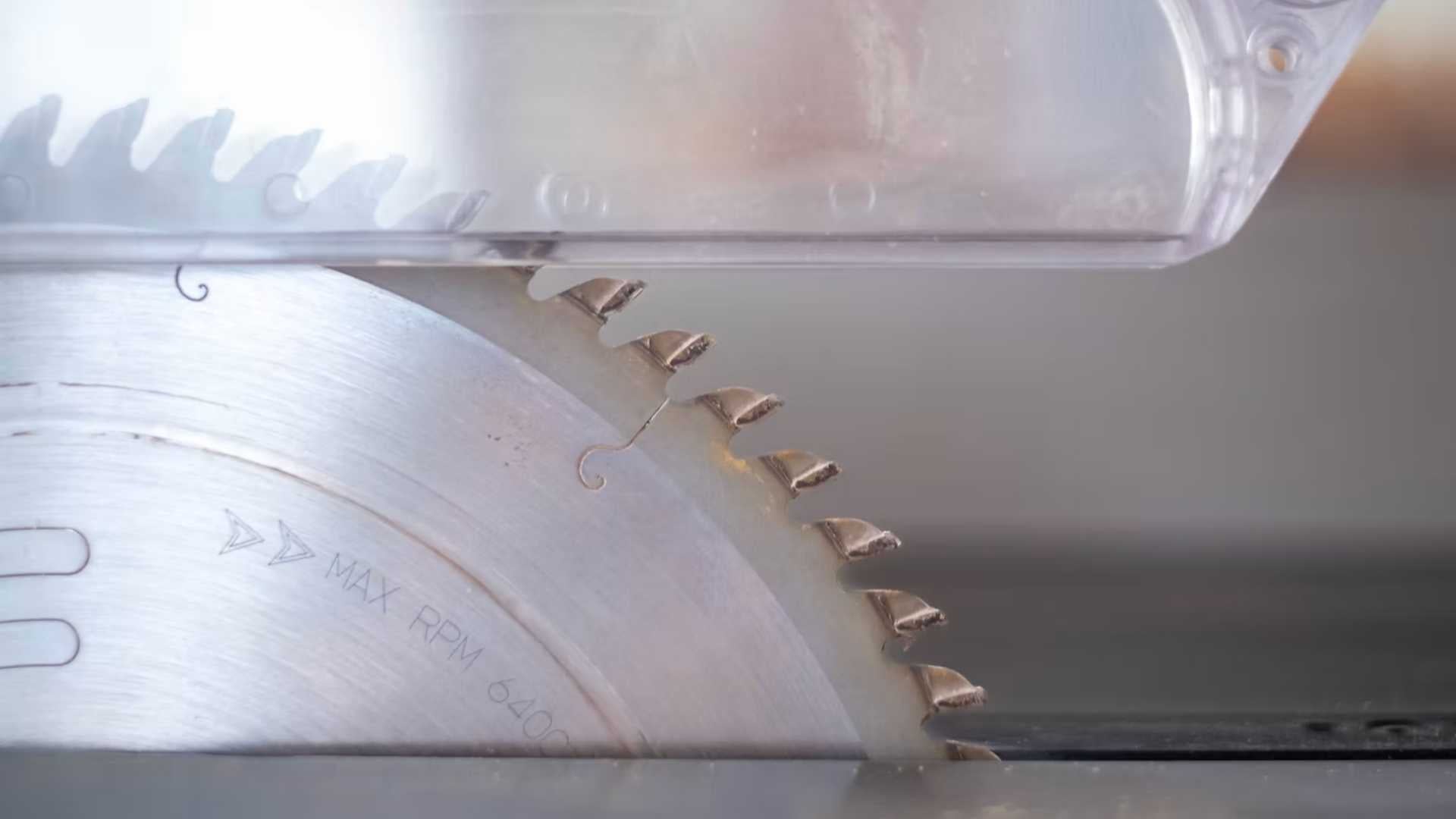 Close-up of a sharp table saw blade with clean carbide teeth, highlighting the importance of using sharp blades to prevent tear-out in woodworking.