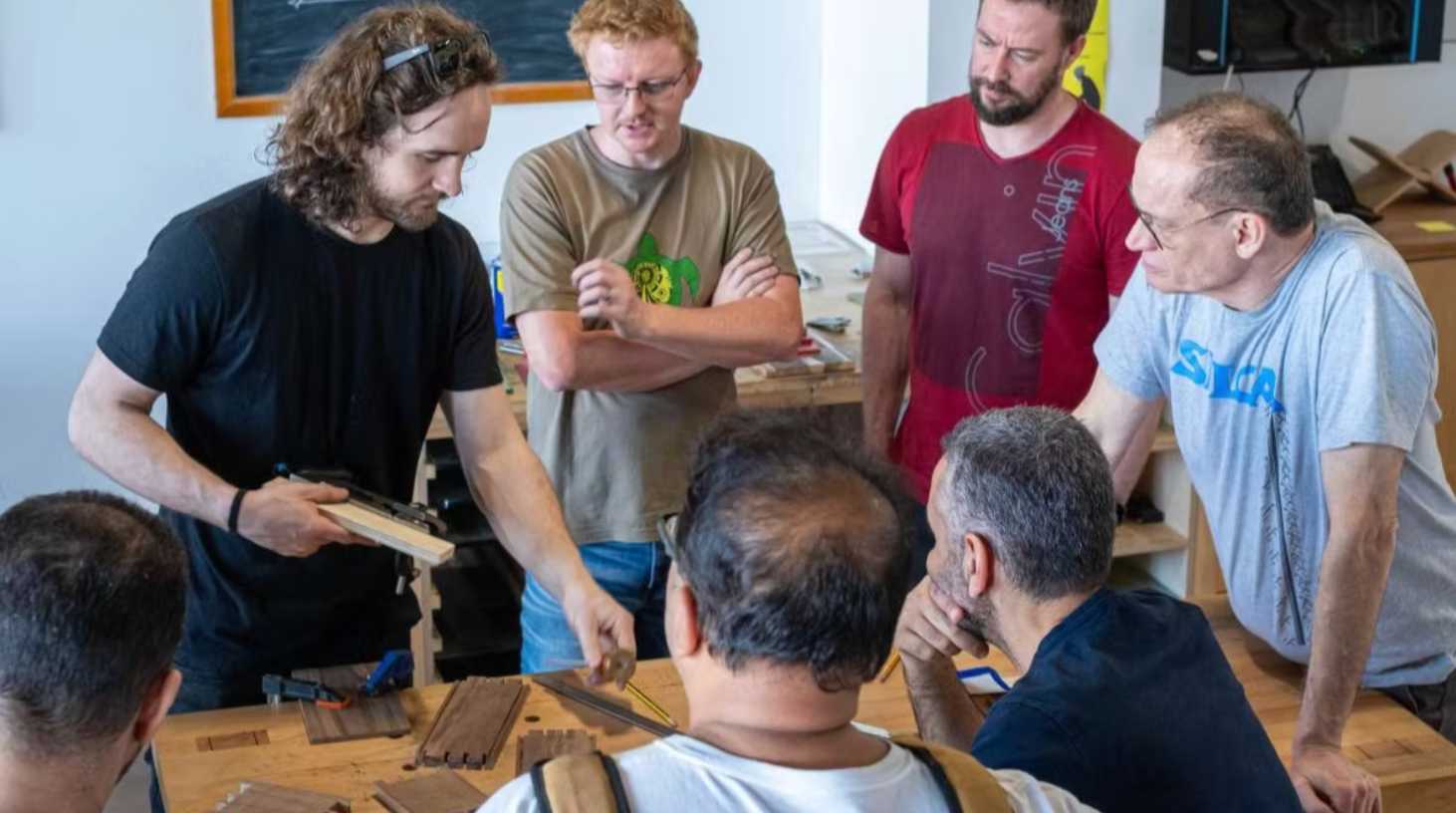 Participants learning woodworking techniques together in a Dubai workshop.