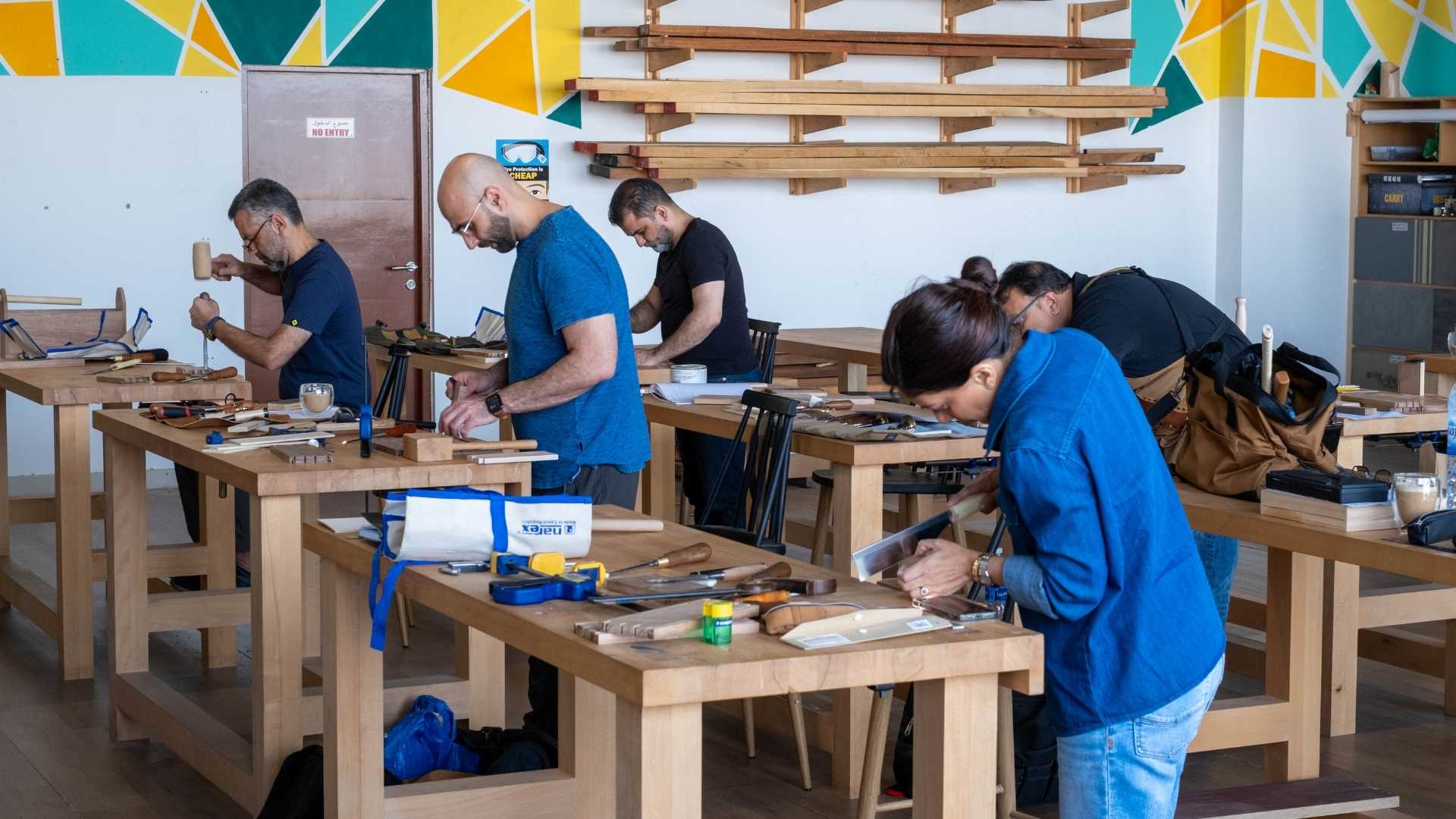 TMS woodworking class Dubai students at benches working with hand tools