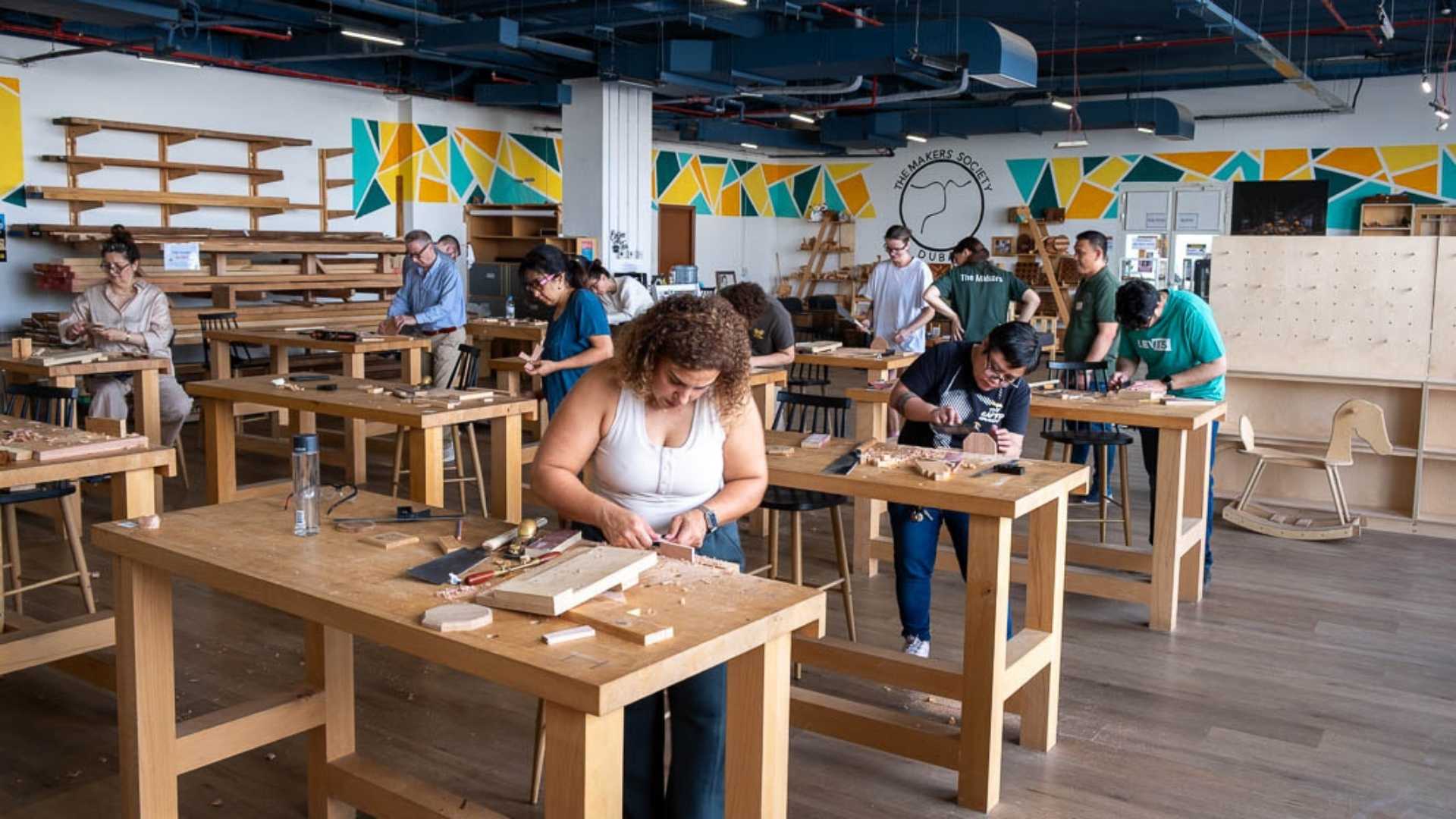Wide view of a woodworking workshop in Dubai with students working at benches.