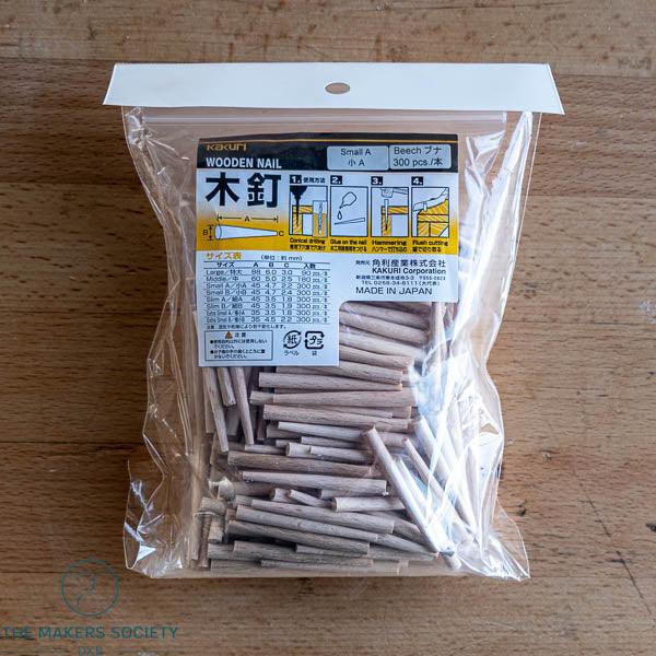Kakuri brand pack of 300 small A beech wooden nails for woodworking, made in Japan, displayed on wooden surface