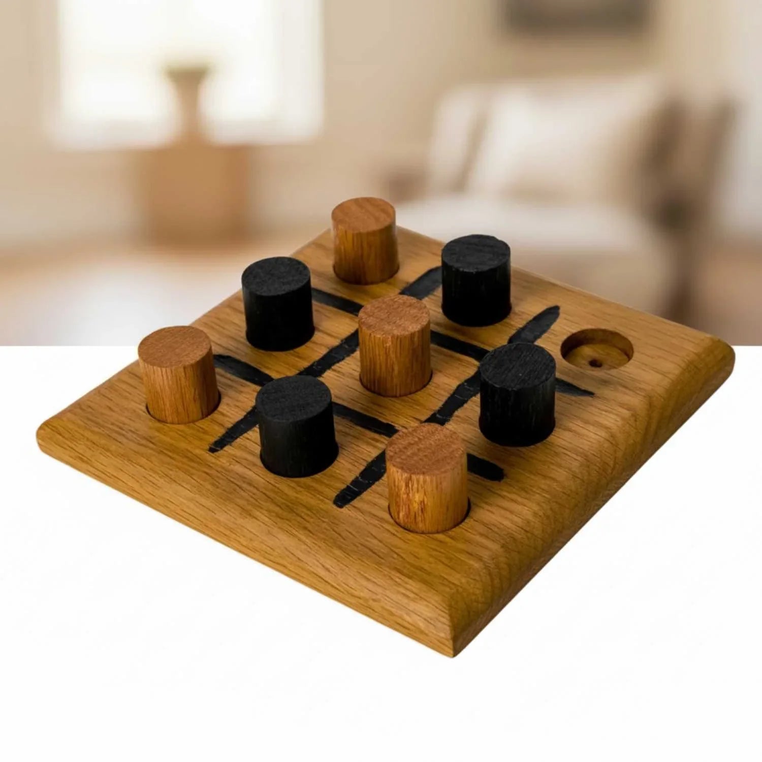 Handmade oak wooden tic-tac-toe game board with black and natural wood cylindrical pieces on white surface