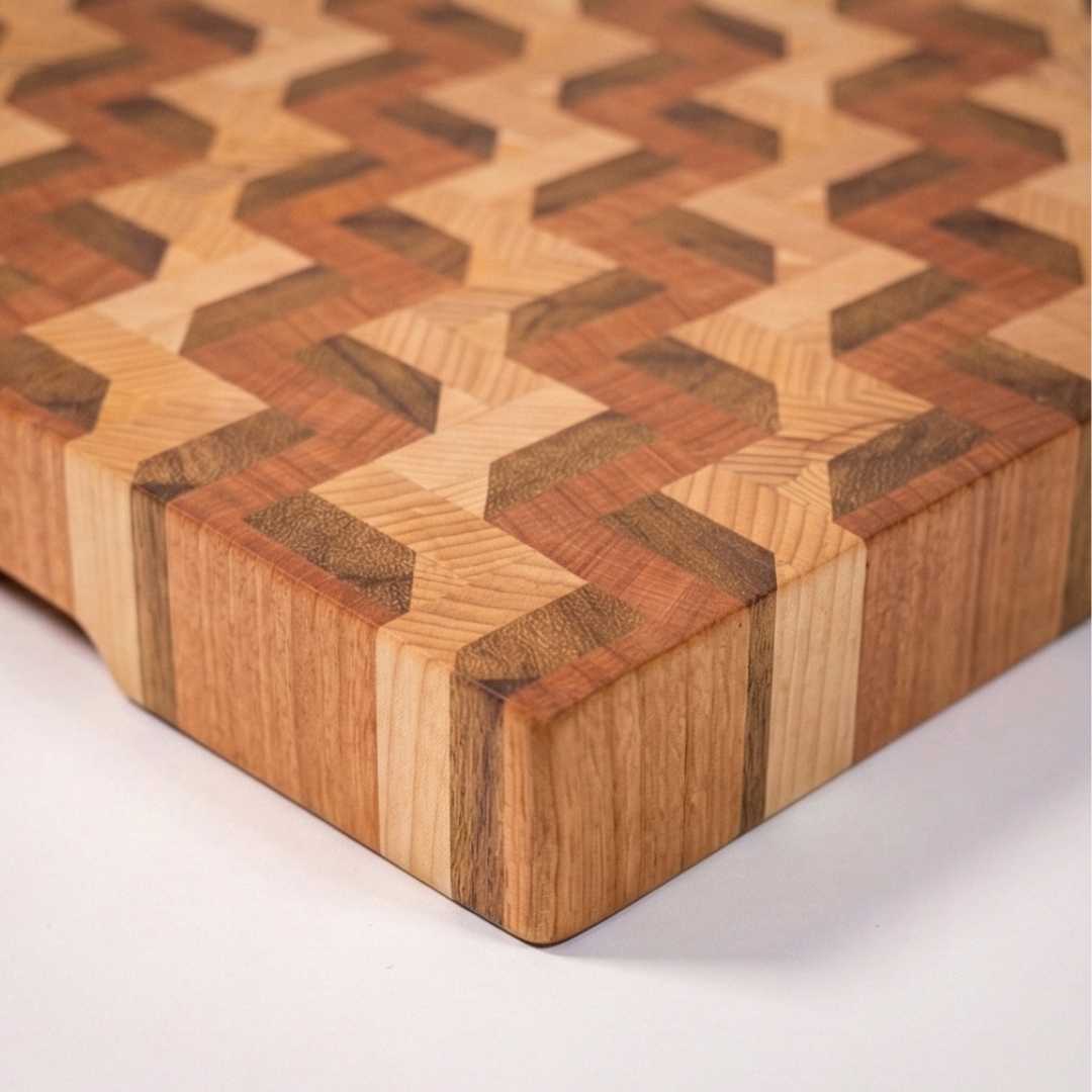 Handmade wooden cutting board with geometric 3D pattern on a white background