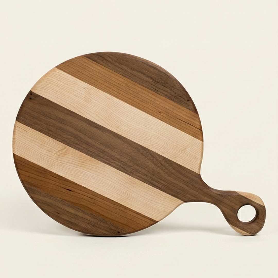 Handmade round wooden serving board with striped walnut and maple pattern, hole handle
