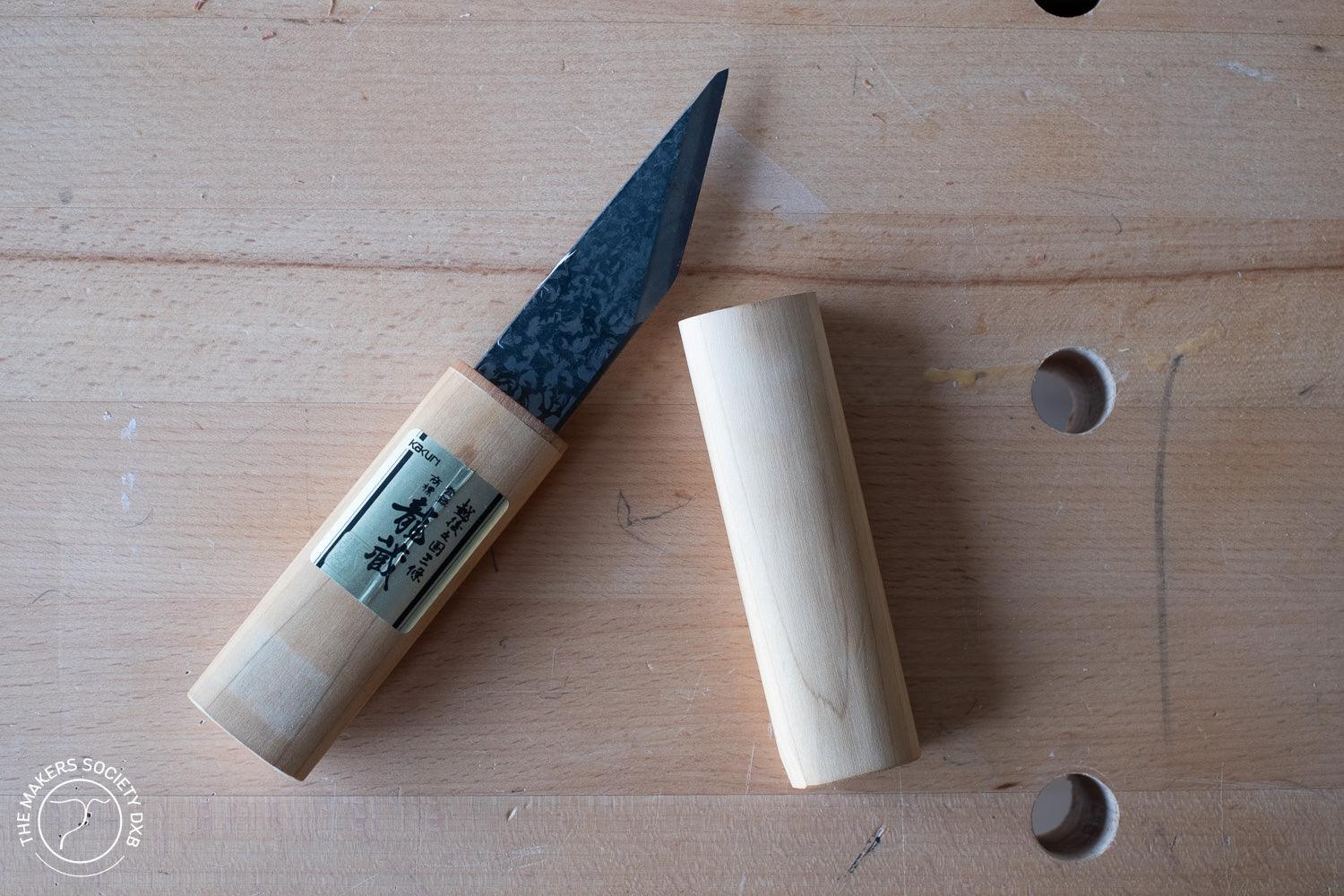 Kakuri 24mm Japanese woodworking carving knife with wooden handle and cap on workbench