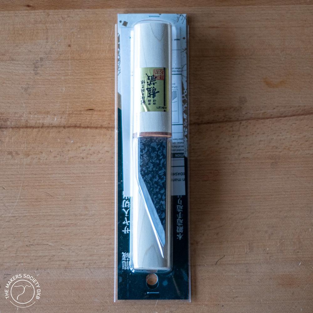 Kakuri 24mm wood carving knife with protective white wooden cap in sealed packaging on wooden surface