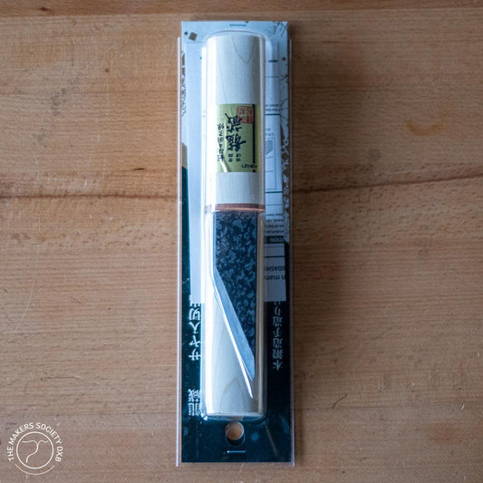 Kakuri 24mm wood carving knife with protective white wooden cap in sealed packaging on wooden surface