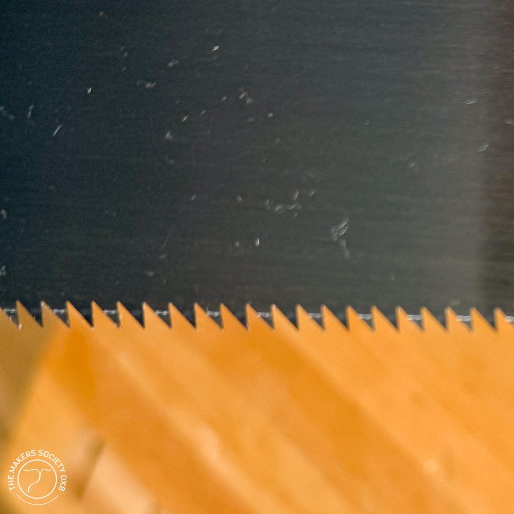 Close-up of sharp double-edge razor saw teeth on a 210mm blade for woodworking