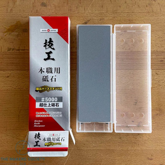 Professional grade Japanese #5000 whetstone with clear plastic case for kitchen knife sharpening on wooden surface