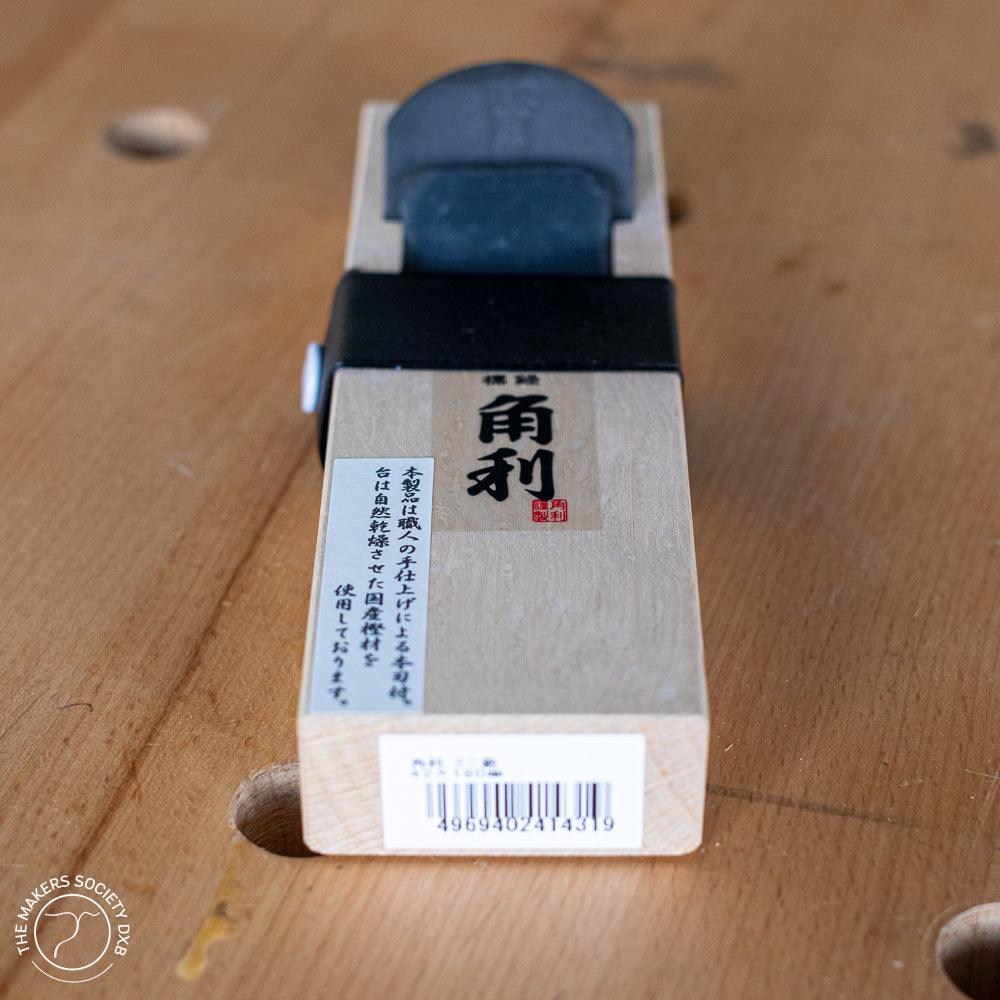 Kakuri mini hand plane with white oak body and black handle on wooden workbench, woodworking tool