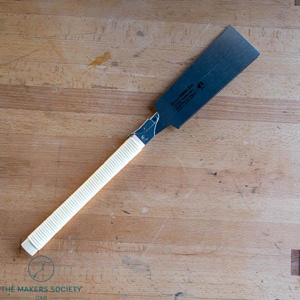 One Touch Spare Blade Type Ryoba Saw 210mm with white wrapped handle on wooden surface