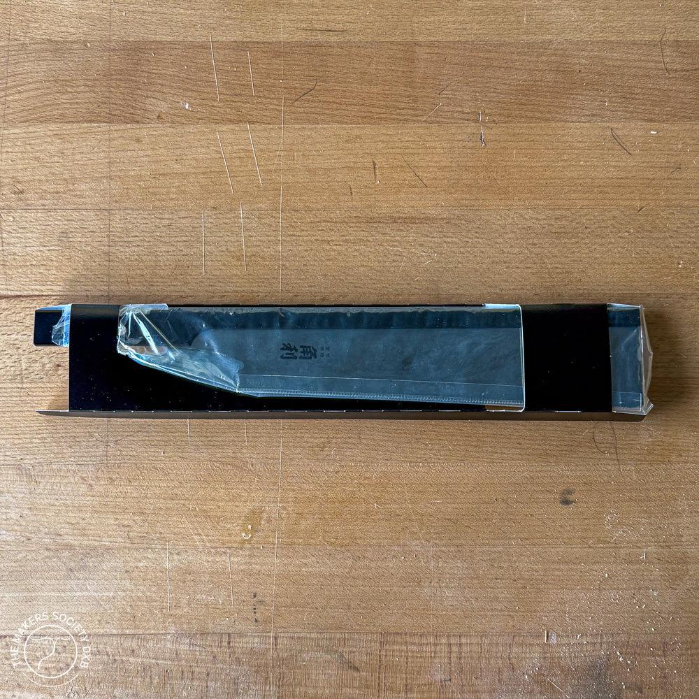 Kakuri spare blade for Sakura handle woodworking tool in black plastic packaging on wooden surface