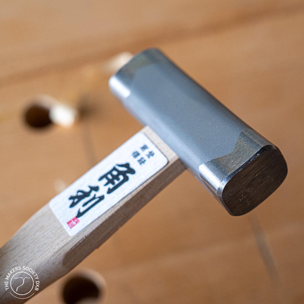 Kakuri square head hammer 225g with wooden handle and Japanese inscription on workbench surface