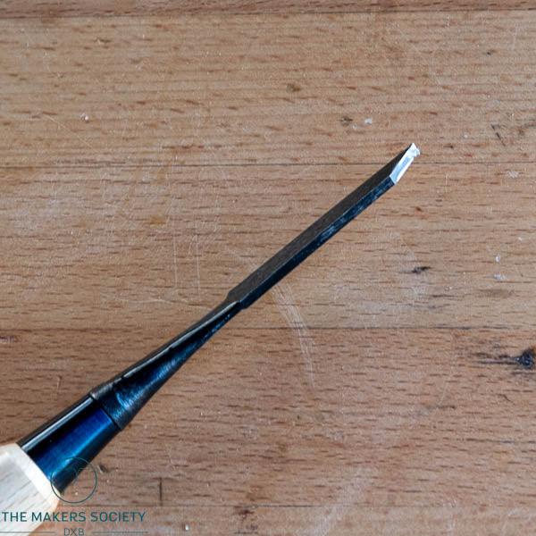 3mm white steel wood chisel with black metal blade on wooden surface from The Makers Society