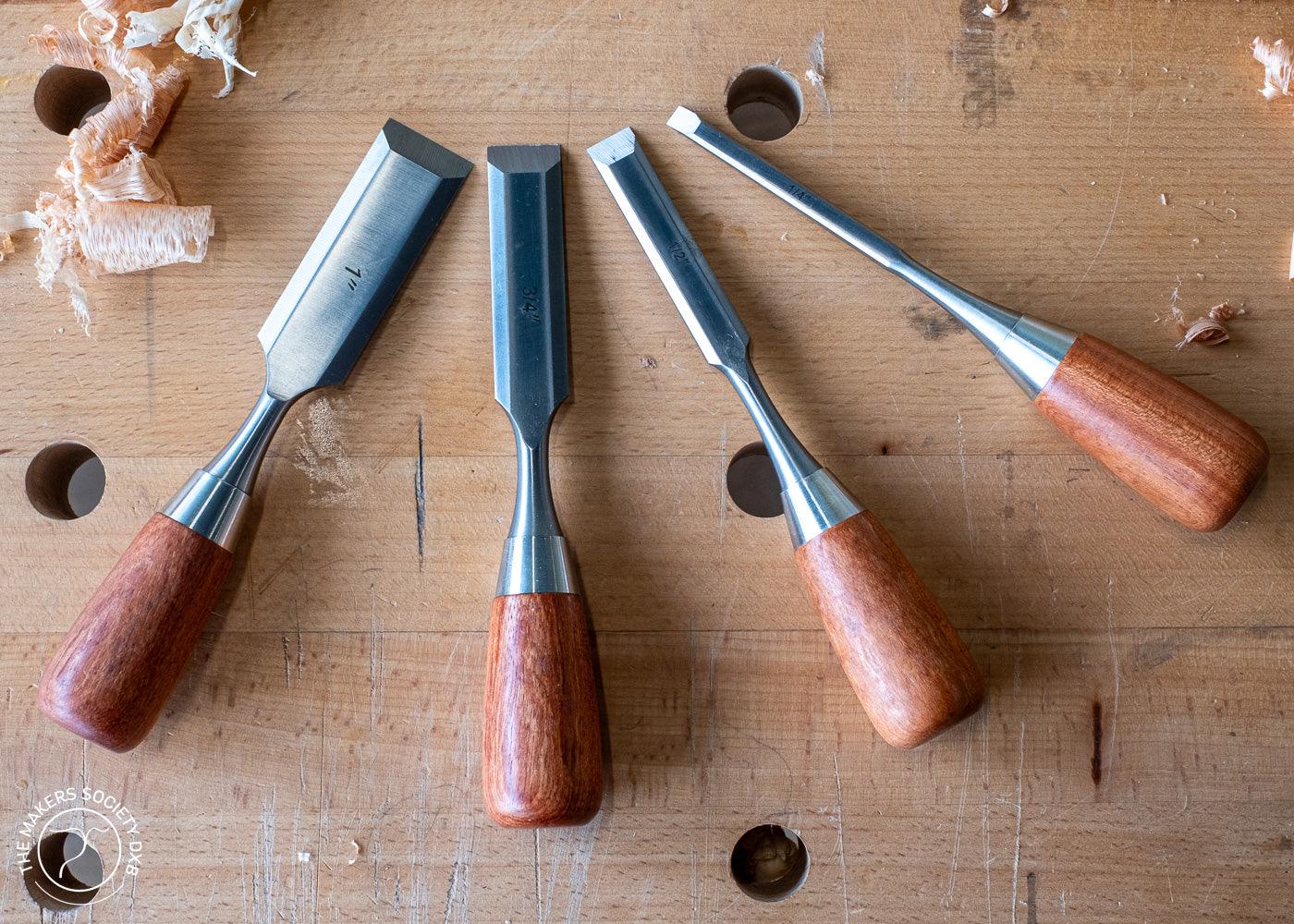Set of four Luban butt chisels with wooden handles on a workbench with wood shavings