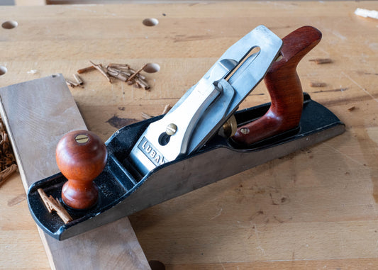 Luban 5 woodworking bench plane with wooden handles on a workbench with wood shavings