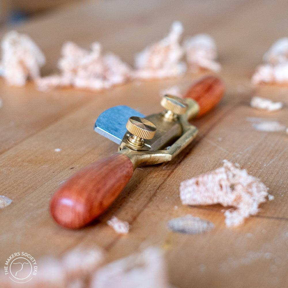 Luban bronze flat spokeshave woodworking tool with wooden handles on wood surface with shavings
