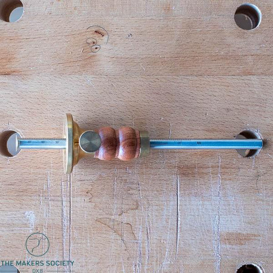 Luban marking gauge woodworking tool with brass and wooden handle on a workbench surface