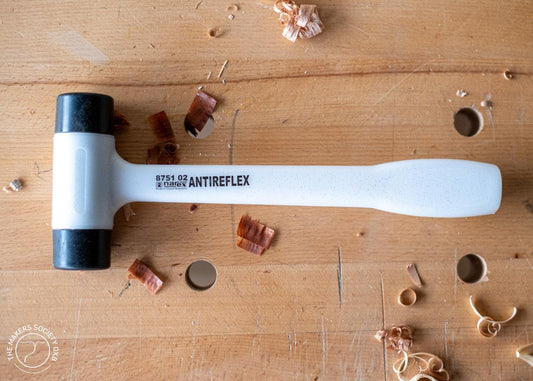 Narex Antireflex double-faced mallet with black plastic heads on wooden workbench with wood shavings