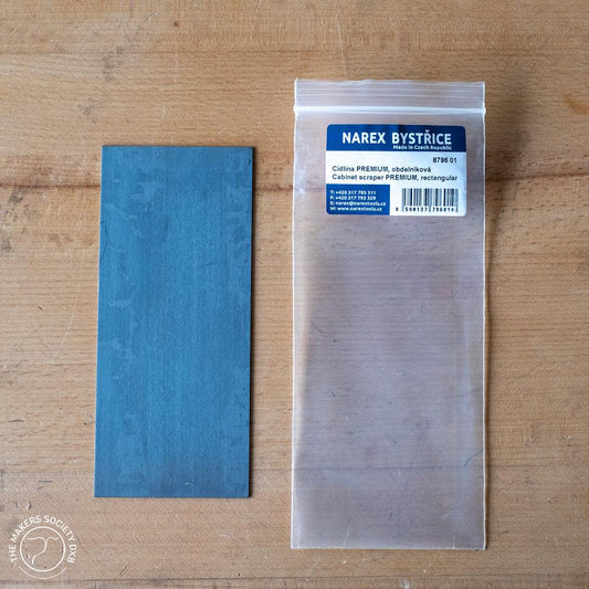 Narex rectangular premium cabinet scraper on wood surface with its clear plastic packaging and blue label