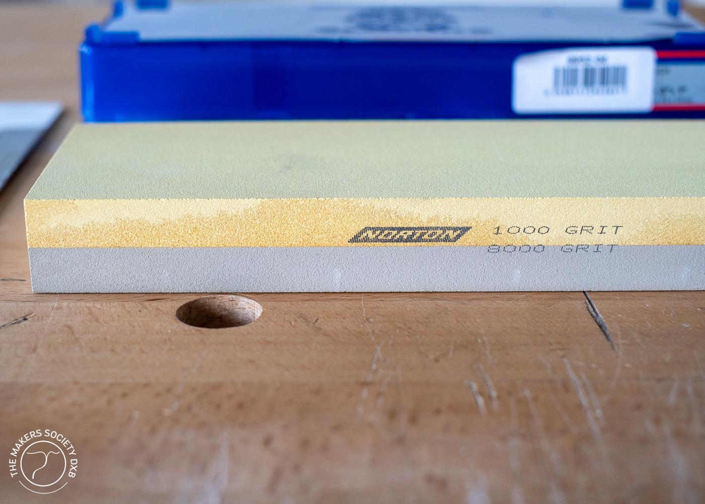Norton Waterstone double-sided sharpening stone with 1000 and 8000 grit on wooden workbench