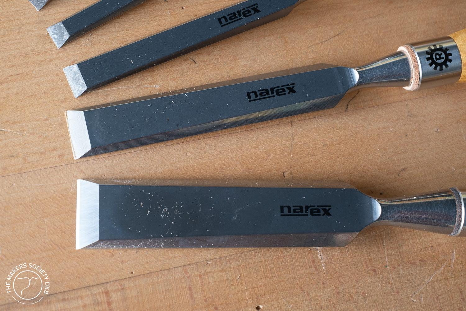 Set of Narex bevel edge chisels with wooden handles on a wooden surface, woodworking tools