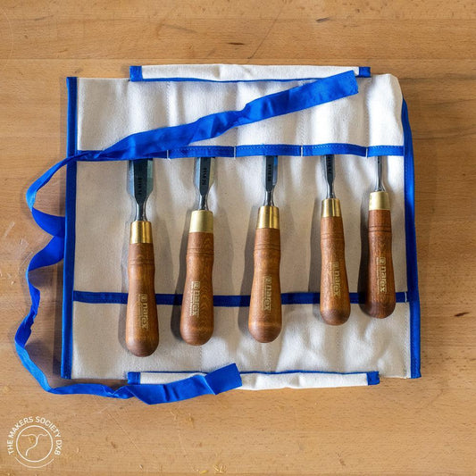 Set of five Narex bevel edge chisels with wooden handles in a premium white canvas roll with blue trim on wood surface