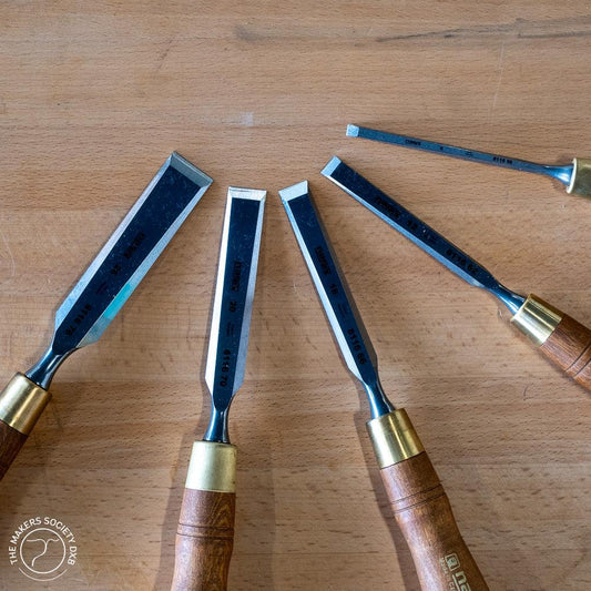 Set of premium Narex bevel edge chisels with wooden handles on a wooden surface