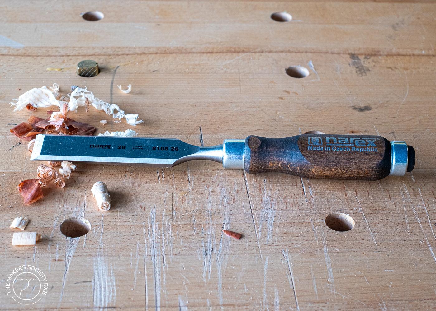 Narex bevel edge chisel with wooden handle on woodworking bench with wood shavings
