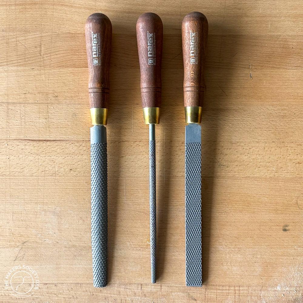 Set of three Narex woodworking rasps with wooden handles on a wooden surface