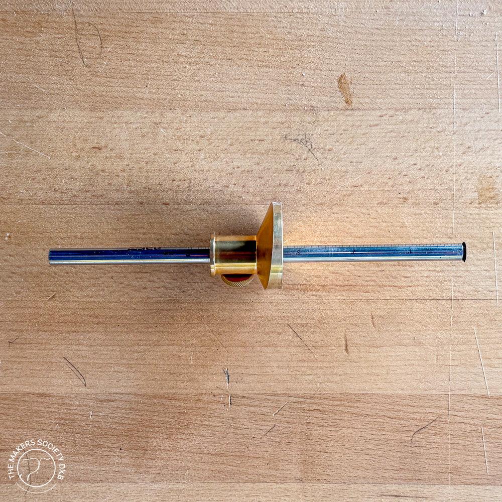 Narex brass wheel marking gauge on a wooden workbench for precision woodworking