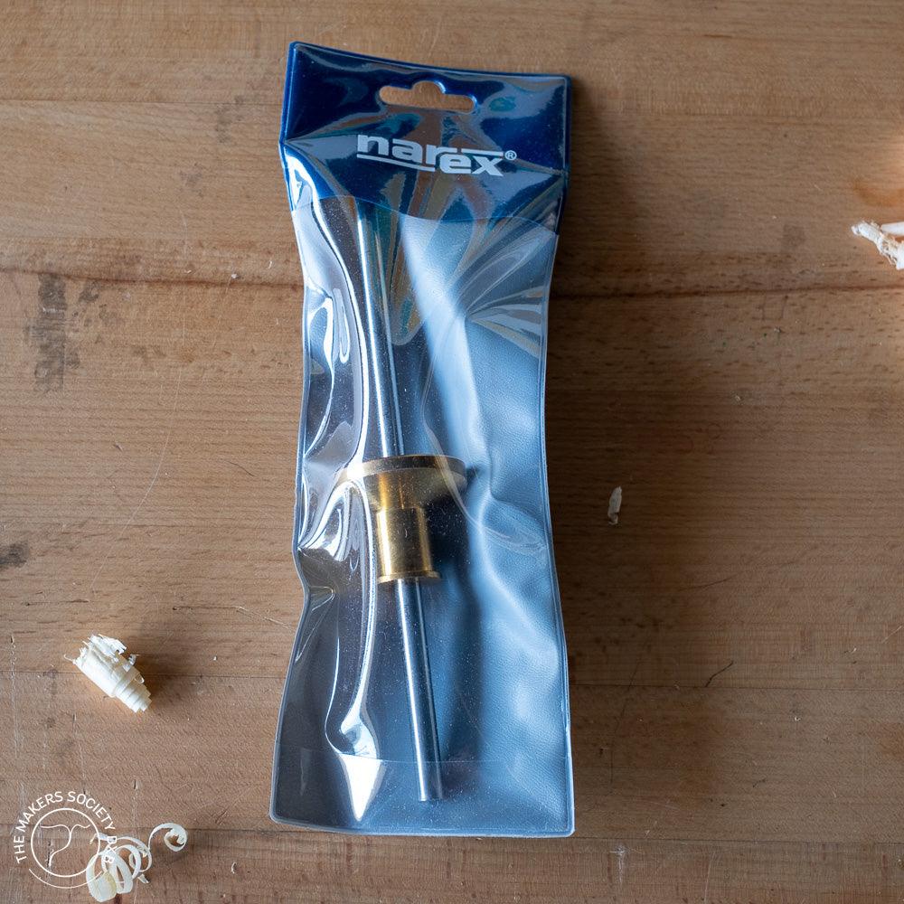 Narex marking gauge woodworking tool in plastic packaging on wooden surface with wood shavings