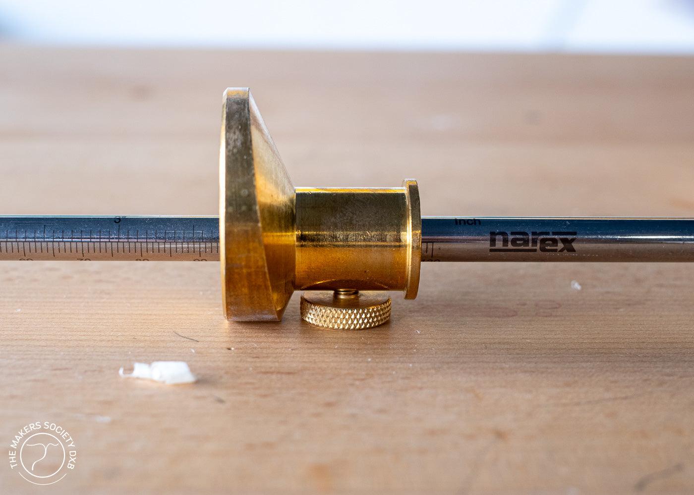 Narex brass wheel marking gauge with steel ruler on wooden surface for precise woodworking measurements
