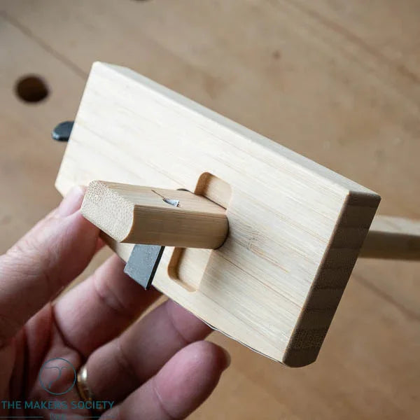 Hand holding a wooden Kakuri marking gauge with a 120mm blade, used for precise woodworking measurements