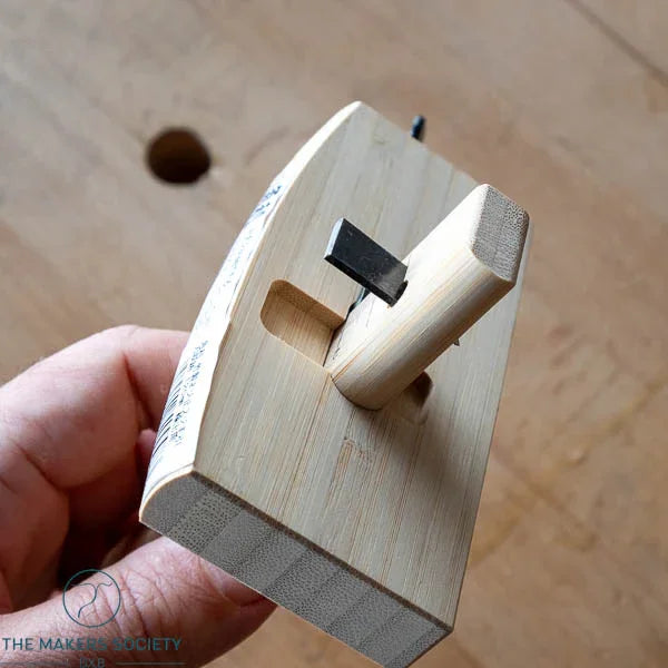 Hand holding a wooden Kakuri marking gauge with a 120mm blade, used for precise woodworking markings
