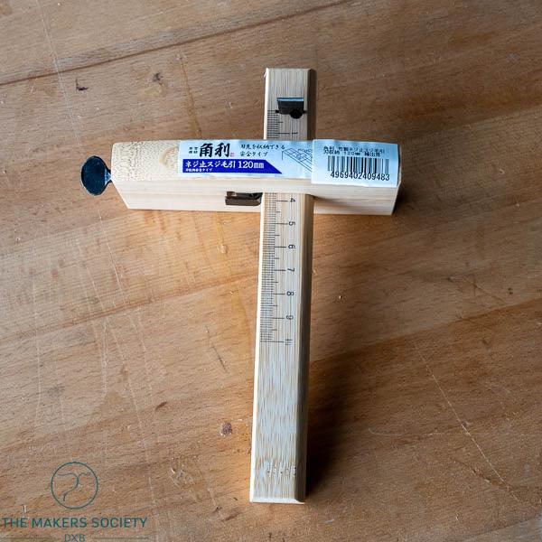 Wooden Kakuri Marking Gauge 120mm with measurement scale on wooden surface, handmade woodworking tool