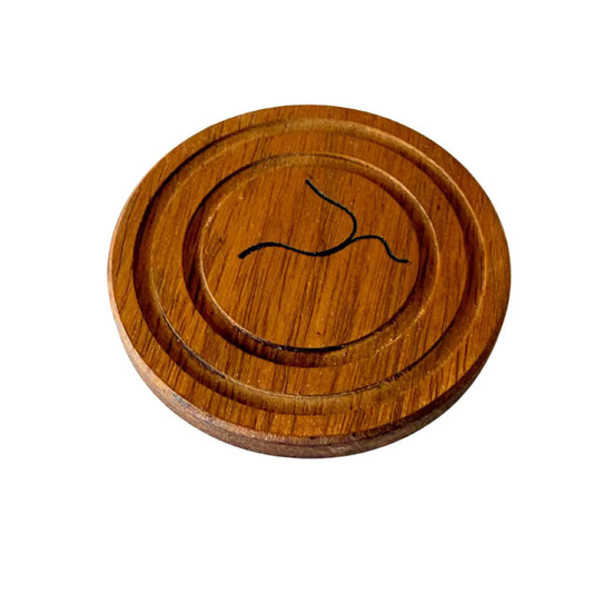 Handmade round wooden coaster with engraved black abstract design, showcasing natural wood grain