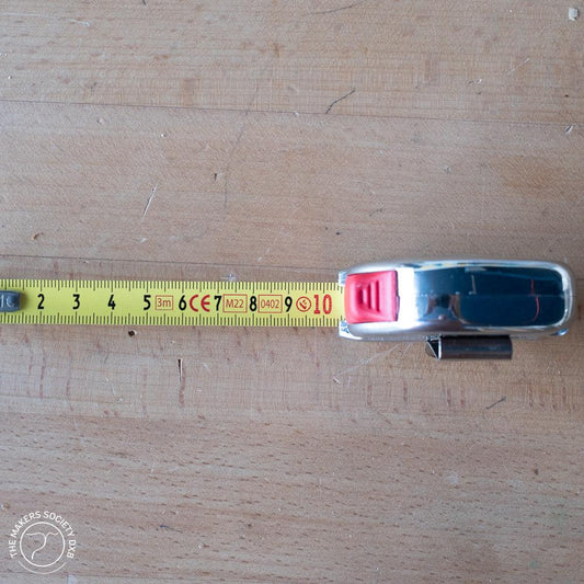 3-meter Class 1 tape measure with metallic casing on wooden surface for precise woodworking measurements