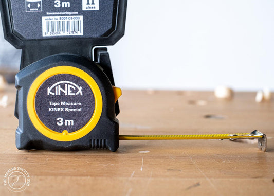 Kinex Special 3m tape measure with yellow and black casing on wooden surface, woodworking tool