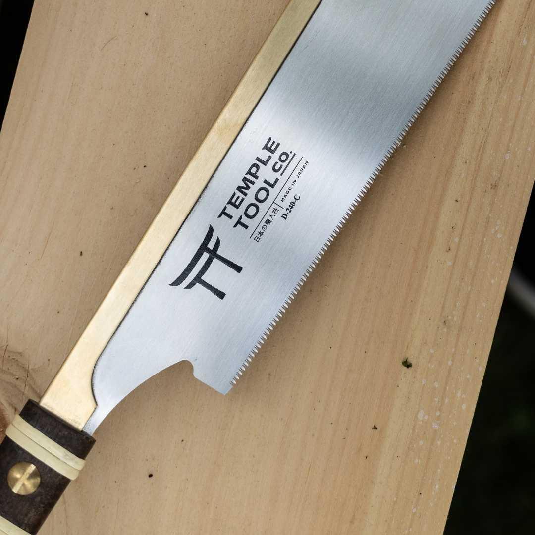 Temple Tool Co. fine crosscut dozugi pull saw with wooden handle on light wood surface