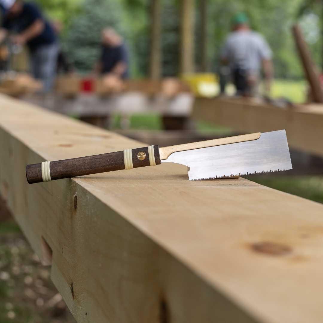 Temple Tool Dozuki pull saw with fine 150mm blade and wooden handle on timber beam outdoors