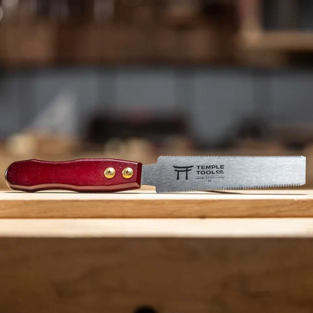 Temple Tool Co. 150mm flush cut pull saw with red wooden handle on wooden surface in workshop