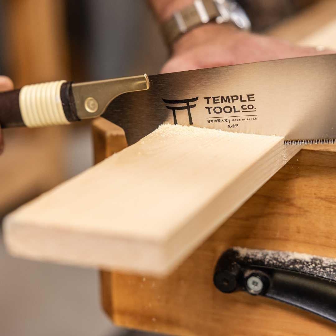 Temple Tool Kataba pull saw cutting a wooden plank on a woodworking bench