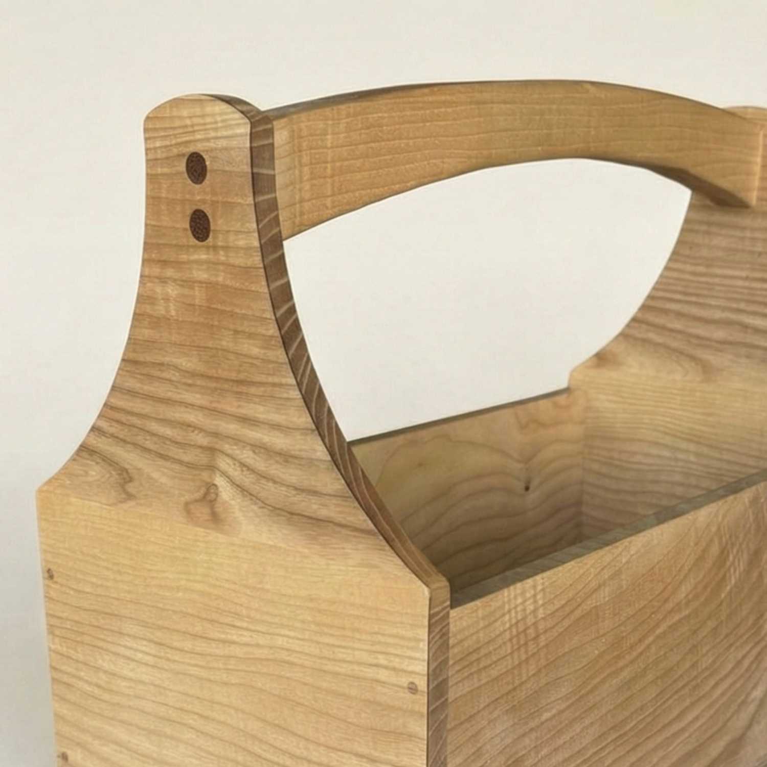 Close-up macro view of the ash wood toolbox course at The Makers Society highlighting the smooth wood texture, organic grain flow, and precise dowel joinery on the curved side panels.