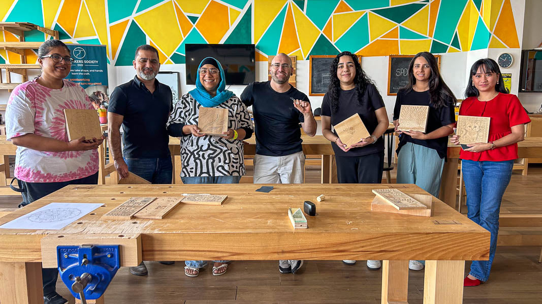 Chip carving class group holding their finished carved boards at The Makers Society, Dubai