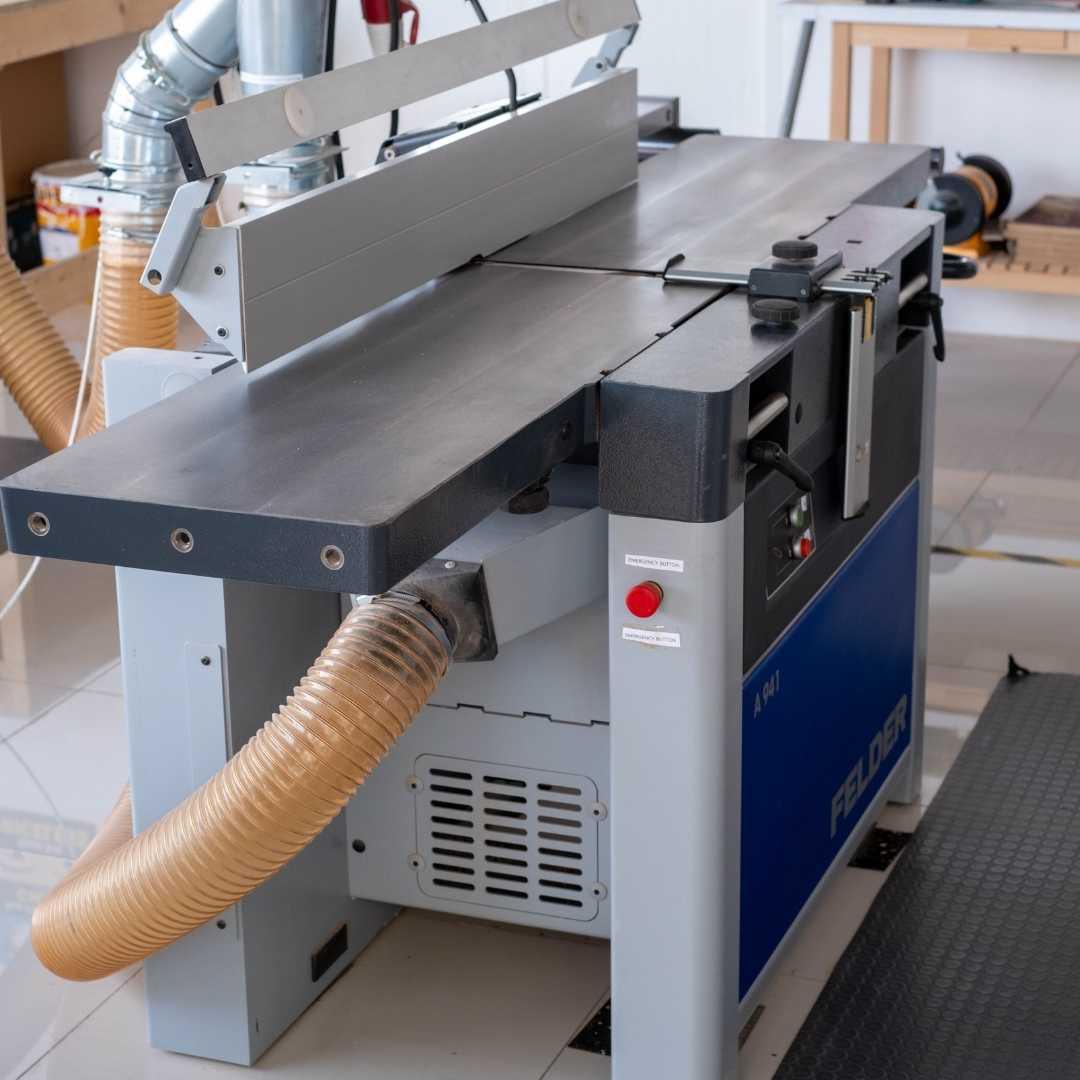 Felder woodworking top planer with a hose attached in a workshop setting