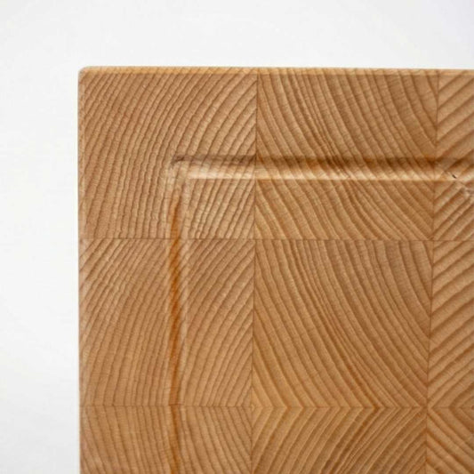 Detail of wooden end grain cutting board with rich natural grain pattern, handmade home goods