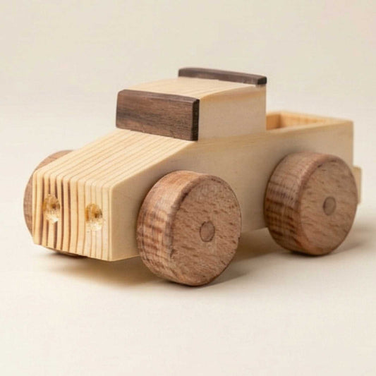 A premium handcrafted wooden toy truck shown at a 3/4 angle, featuring natural pine and walnut wood accents on a clean, off-white studio background.